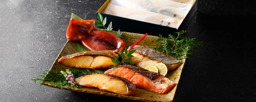 粕漬詰合せを焼いて盛り付けたギフトセットのイメージ。化粧箱入り。Ｔシリーズページへ