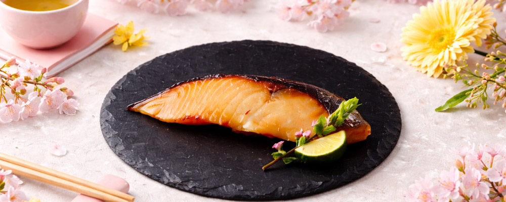 魚久 銀だら京粕漬の焼き上がりを黒皿に盛り付けた春の食卓イメージ