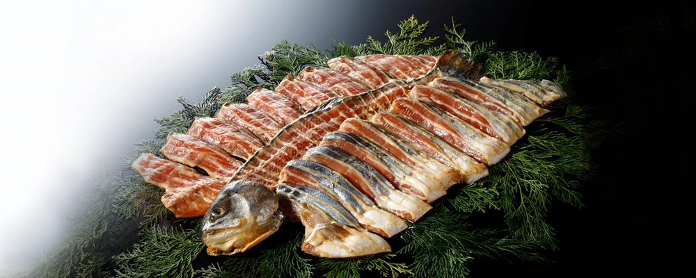 魚久ﾄﾗｳﾄｻｰﾓﾝ1本漬 調理前の切り身を檜葉に乗せたイメージ。特別詰め合わせカテゴリページへ
