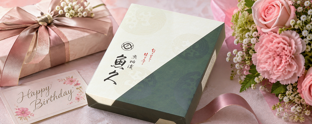 魚久の京粕漬の箱と花、ラッピングしたプレゼントを並べた誕生日ギフトのイメージ