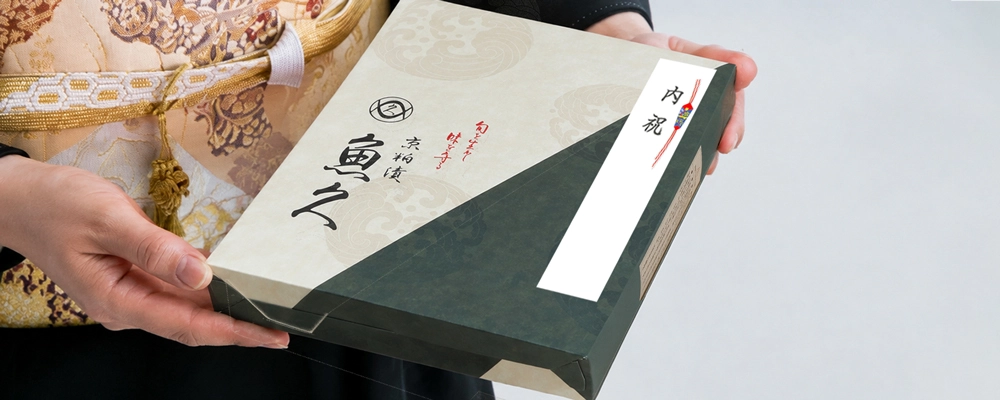 内祝いののしを付けた魚久の贈答箱を着物姿の女性が手に持っている様子