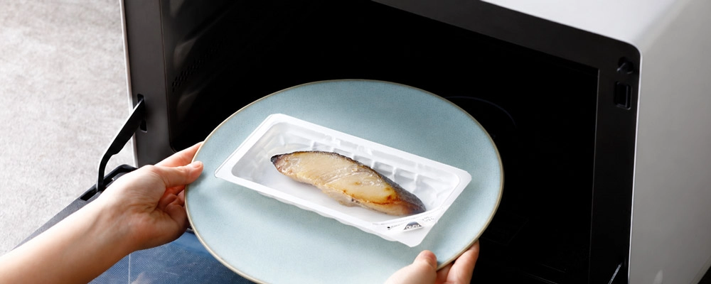 電子レンジに入れようとしている魚久の冷凍焼魚ぎんだら京粕漬。冷凍焼魚LYシリーズのカテゴリページへ